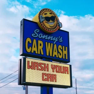 A car wash pylon sign with an electronic message board.