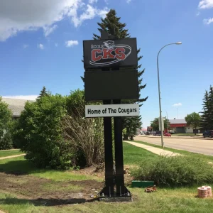A pylon sign for a school that has an electronic message board underneath the main sign.